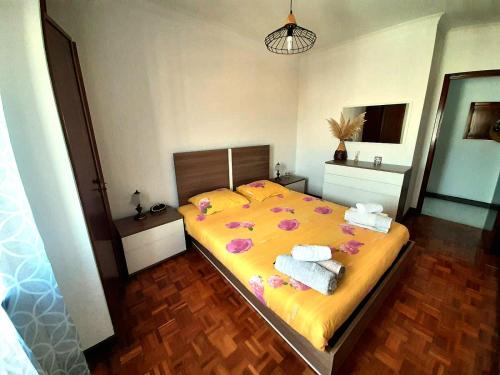 a bedroom with a large bed with towels on it at Appartement Quartier Calme sur la côte sauvage! 400m plage in Póvoa de Varzim