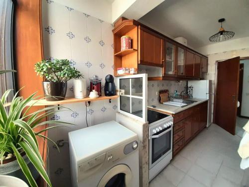 a small kitchen with a stove and a sink at Appartement Quartier Calme sur la côte sauvage! 400m plage in Póvoa de Varzim