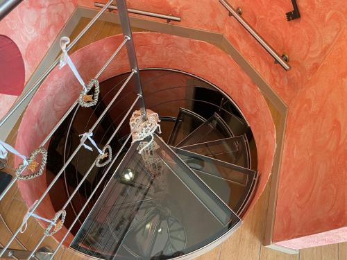 eine Wendeltreppe in einem Gebäude mit einem runden Fenster in der Unterkunft Appartamento montano in La Thuile