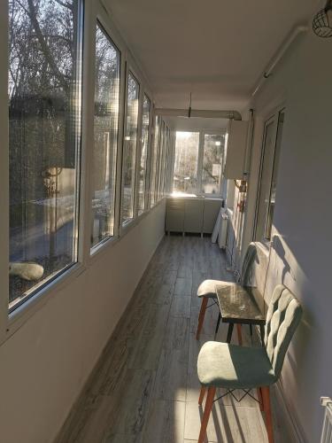 an empty hallway with a chair and windows at Casa Potcoava in Târgu-Mureş