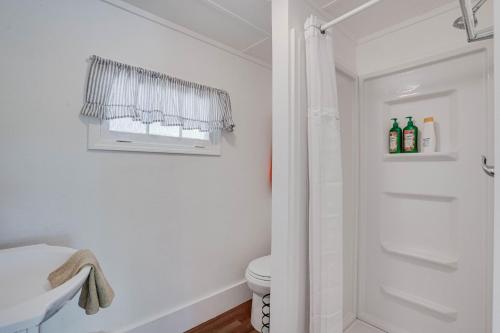 a white bathroom with a shower and a toilet at Lakeshore Fishing Cabins #4 in Lake Ozark