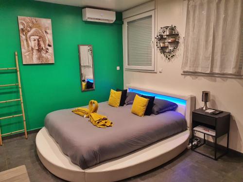 Cama en habitación con pared verde en Suite Jacuzzi Privatif Plage Des Catalans, en Marsella