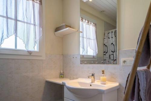 y baño con lavabo y espejo. en Gîtes Le Bois Berranger en Saint-Urbain