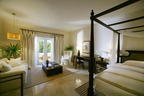 a bedroom with a bed and a desk and a couch at Casa Colonial Beach & Spa in San Felipe de Puerto Plata