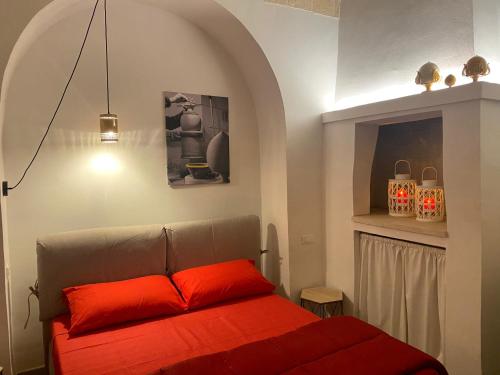 a bedroom with a bed with a red pillow at Via Caputo 51 in Grottaglie