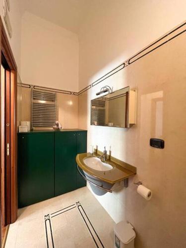 a bathroom with a sink and a green cabinet at La Casa sul Corso in Agropoli