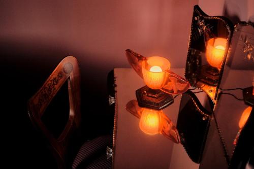 a mirror with lights on it next to a chair at Hotel Ulysses, a Member of Design Hotels in Baltimore