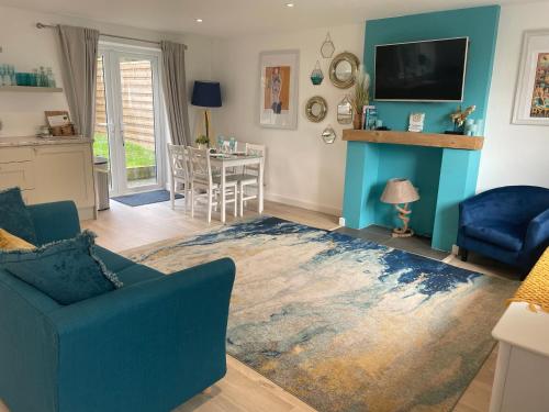 uma sala de estar com um sofá azul e um tapete azul em The Bolt Hole Hythe panoramic coast and sea views em Kent