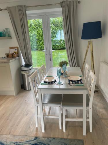 mesa de comedor blanca y sillas con ventana en The Bolt Hole Hythe panoramic coast and sea views, en Kent