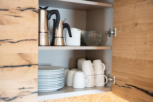 a cupboard with plates and utensils in it at Chalet Silvesterhütte in Seiser Alm 