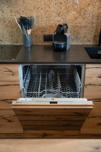 a dishwasher filled with dishes on a kitchen counter at Chalet Silvesterhütte in Seiser Alm 