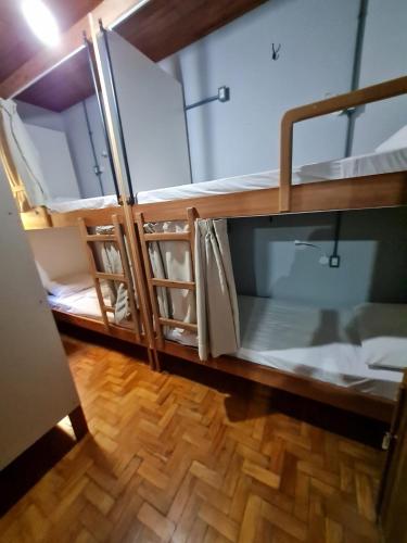a room with two bunk beds and a wooden floor at HOSTEL BADULACK in Capitólio