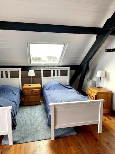 - une chambre mansardée avec 2 lits et une fenêtre dans l'établissement Maison avec vue mer à Port Manec'h, GR 34 à pied, à Névez