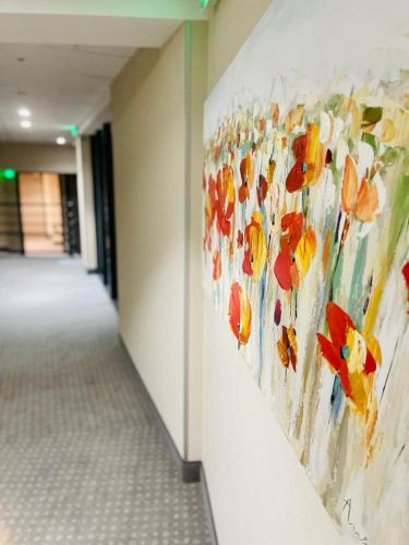 a painting of flowers on a wall in a hallway at Au Coeur Des Bulles in Loches-sur-Ource