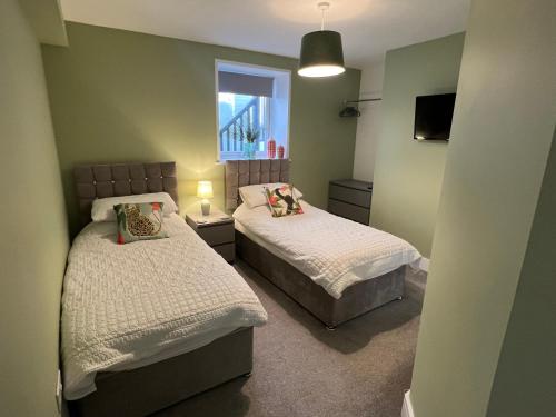 a bedroom with two beds and a window at Regent Apartment - Two bedroomed Holiday Flat in Ilfracombe