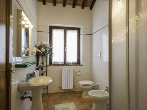 a bathroom with two sinks and a toilet and a window at Tenuta La Casetta in Casciana Terme