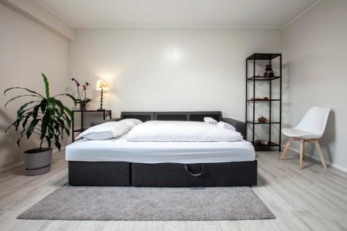 a bedroom with a large bed and a chair at Apartments Reykjavik in Reykjavík