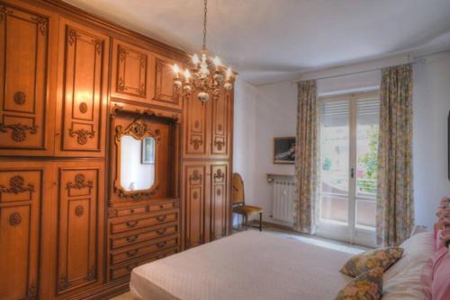 una camera con letto, specchio e finestra di Ampio appartamento per 9 persone a pochi passi dal mare ad Albenga