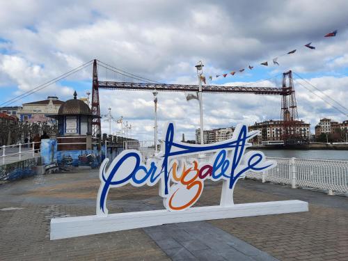 a sign on a pier with a bridge in the background at Apartamento Portugalete Gran Bilbao 3 dormitorios - 3 bedrooms in Portugalete