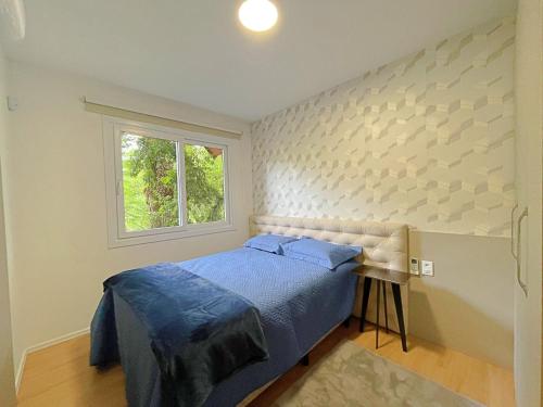 Un dormitorio con una cama azul y una ventana en Casa Encantos de Canela - Refúgio da família, en Canela