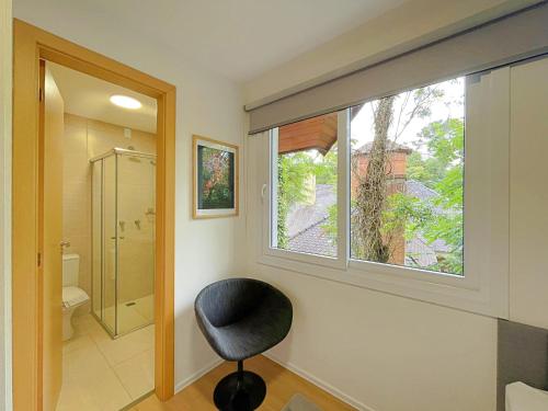 baño con ventana y silla en Casa Encantos de Canela - Refúgio da família, en Canela
