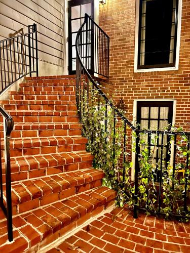 a brick stairway with a black railing next to a building at The Poppy Georgetown Guesthouse and Gardens in Washington