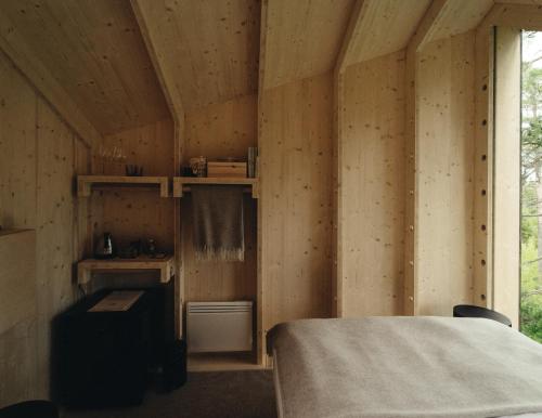 Zimmer mit einem Bett in einer Holzhütte in der Unterkunft Hilltop Forest in Inkoo