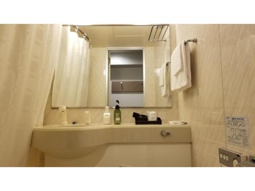 een badkamer met een wastafel en een spiegel bij Sun Royal Utsunomiya - Vacation STAY 02516v in Utsunomiya