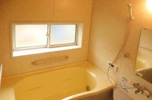 a bathroom with a tub and a window at Active House Ryuo - Vacation STAY 04019v in Shimotakai