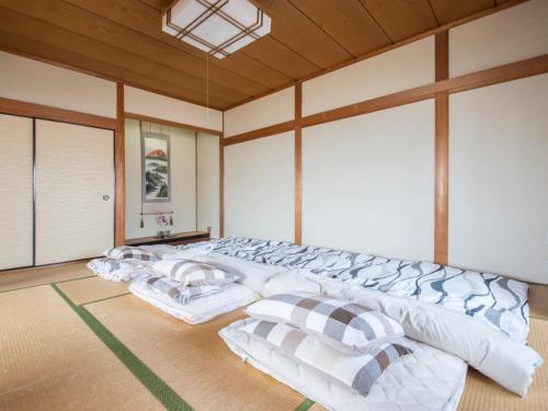 ein großes Bett mit Kissen in einem Zimmer in der Unterkunft Minpaku Yamamoto - Vacation STAY 13868 in Izumiotsu