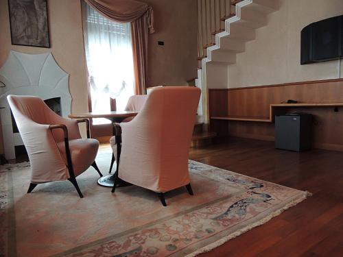 a room with a table and chairs and a staircase at Grand Hotel Astoria in Lavarone