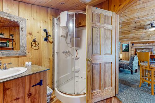 a bathroom with a shower and a sink at Garage Cottage in Gilford