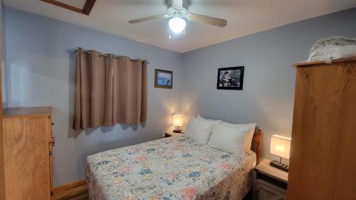 a bedroom with a bed and a ceiling fan at Codroy Valley Cottage Country 