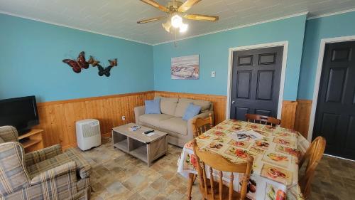 a living room with a table and a couch at Codroy Valley Cottage Country in Doyles