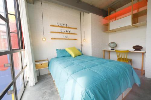 1 dormitorio con 1 cama con edredón azul en Indie Studio, en Medellín