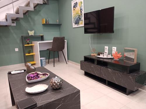 sala de estar con TV y mesa negra en Kamares Apts - Antonis Cozy Maisonette, en La Canea