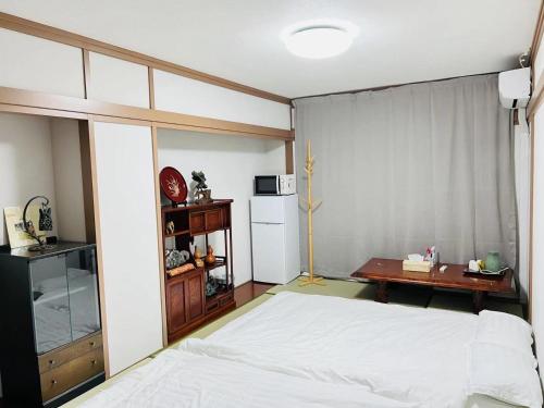 1 dormitorio con cama blanca y escritorio en FUKUINN - Vacation STAY 19245v, en Takamatsu
