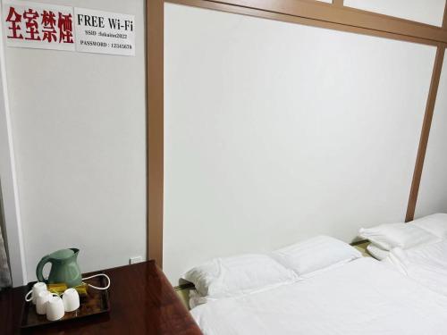 1 dormitorio con cama, mesa y cartel en FUKUINN - Vacation STAY 19245v, en Takamatsu