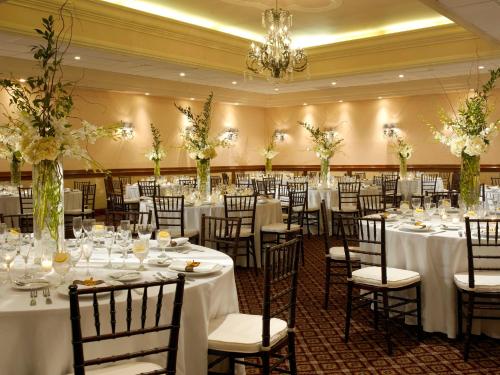 um salão de banquetes com mesas e cadeiras com toalhas de mesa brancas em Holiday Inn Miami Beach-Oceanfront, an IHG Hotel em Miami Beach