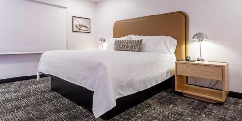 a hotel room with a large bed and a night stand at Wendover Nugget Hotel & Casino by Red Lion Hotels in West Wendover