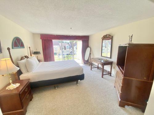 韋爾斯的住宿－海濱之村酒店，一间卧室配有一张床、一个梳妆台和一扇窗户。