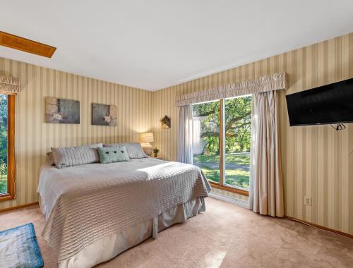 a bedroom with a bed and a flat screen tv at Yogi Bear's Jellystone Park Camp-Resort Wisconsin Dells in Wisconsin Dells