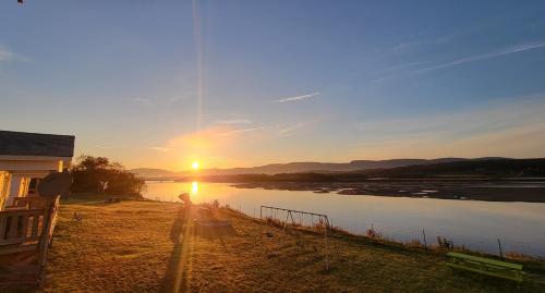 a sunset over a river with the sun setting at Codroy Valley Cottage Country in Doyles
