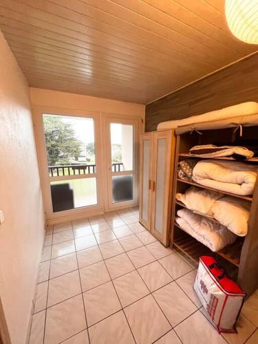 une chambre avec une grande fenêtre et une chambre avec des serviettes dans l'établissement T2 Mimizan plage, à Mimizan