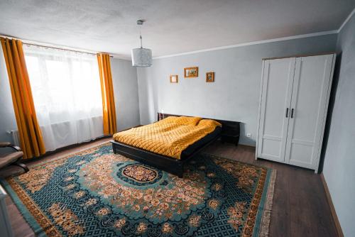 a bedroom with a bed and a rug and a window at Casa cu Dor in Viştea de Sus