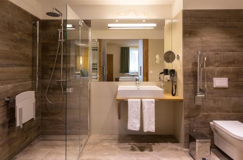 a bathroom with a sink and a shower at Hotel Schlof Guat in Oberpullendorf