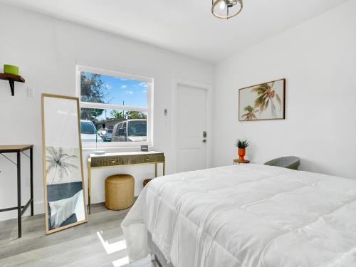 a white bedroom with a bed and a sink at Rainbow Motel Miami in Miami