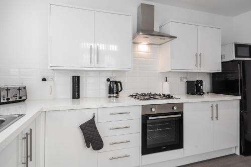 a white kitchen with white cabinets and a stove top oven at DENEBANK LODGE - Strictly NO Parties in Liverpool