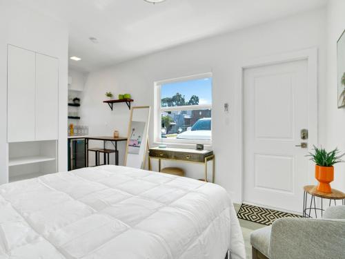 a white bedroom with a large bed and a window at Rainbow Motel Miami in Miami