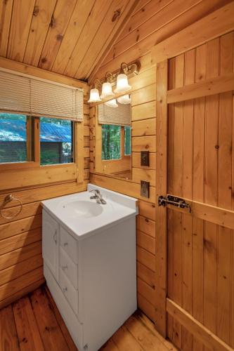 a bathroom with a white sink in a wooden room at Yogi Bear's Jellystone Park Camp-Resort Wisconsin Dells in Wisconsin Dells